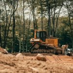 yellow and black heavy equipment on brown soil